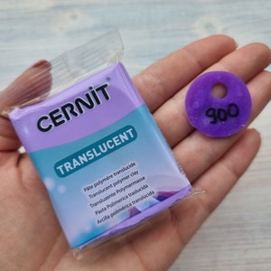 May include: A pack of translucent polymer clay by CERNIT. The pack is purple and white and has the text "TRANSLUCENT" on it. A small purple disc with the number 900 on it is also shown.