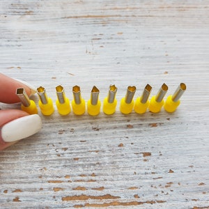 Könnte beinhalten: Ein Set mit 10 Ausstechern aus Metall mit gelben Griffen in verschiedenen Formen, darunter Sterne, Herzen und Kreise.