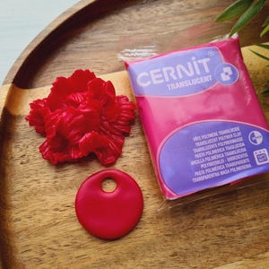 May include: A white ceramic mug with a black handle and the text "But First, Coffee" in a black, handwritten-style font. The mug is on a white surface.