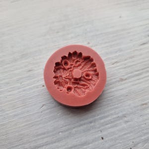 Puede incluir: Un molde de silicona rojo con un dise&ntilde;o detallado de una corona de flores. El molde est&aacute; dise&ntilde;ado para hacer art&iacute;culos decorativos como adornos para pasteles o joyas.