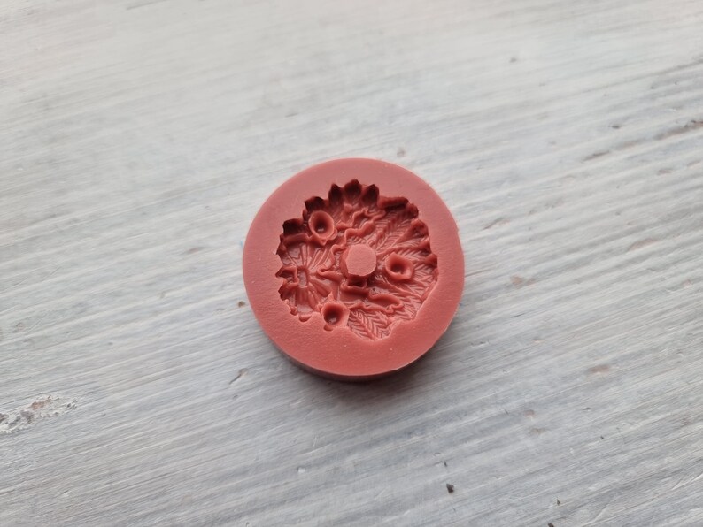 Puede incluir: Un molde de silicona rojo con un dise&ntilde;o detallado de una corona de flores. El molde est&aacute; dise&ntilde;ado para hacer art&iacute;culos decorativos como adornos para pasteles o joyas.