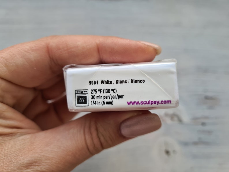 May include: A white Sculpey clay package with text including "5001 White", baking instructions at 130&deg;C for 30 minutes, and 6 mm thickness. The website www.sculpey.com is also visible.