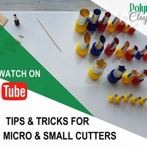 May include: An assortment of colorful polymer clay cutters in various shapes and sizes, including stars and cylinders, arranged on a white surface. The image includes the text "TIPS & TRICKS FOR TINY, MICRO & SMALL CUTTERS" and a YouTube logo.