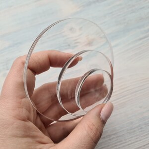 May include: Three clear acrylic circles of different sizes stacked on top of each other.