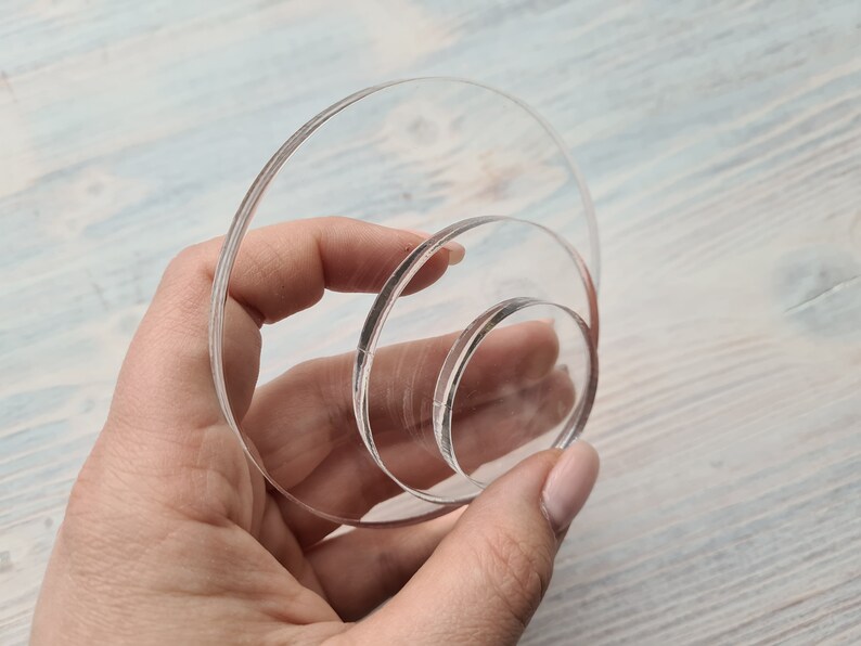 May include: Three clear acrylic circles of different sizes stacked on top of each other.