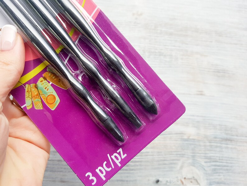 Puede incluir: Un paquete de tres herramientas de metal negro con puntas redondeadas. El paquete es morado y tiene el texto "3 pc/pz" impreso en la parte inferior.