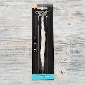 May include: White plastic ball tool for polymer clay with two ball sizes, 0.5mm and 3mm. The tool is packaged on a black and white card with the text "Cernit Accessories Ball Tool".