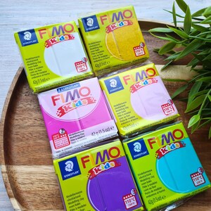 May include: Five different colors of Fimo Kids oven-bake modeling clay. The colors are white, pink, yellow, light pink, and turquoise. Each package is 42 grams (1.5 ounces).