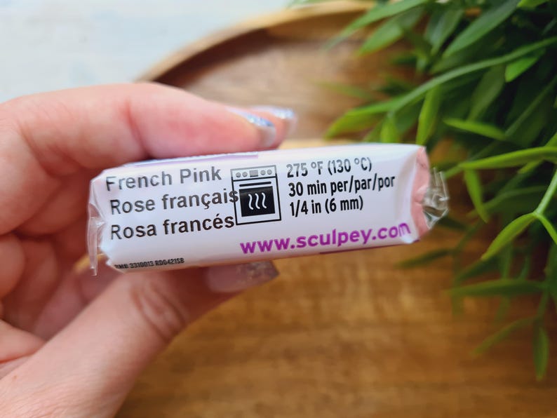 May include: A package of French Pink polymer clay. The label includes the text "French Pink", "Rose fran&ccedil;ais", and "Rosa franc&eacute;s". It also shows baking instructions: 275&deg;F (130&deg;C) for 30 minutes, and 1/4 in (6 mm). The website www.sculpey.com is also visible.