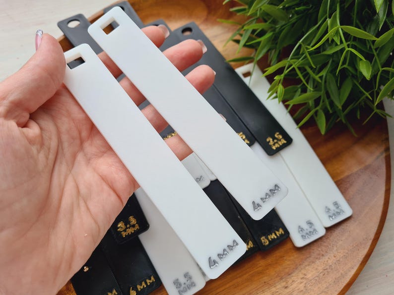 Peut inclure: Plusieurs outils rectangulaires blancs et noirs avec un trou carr&eacute; en haut. Les outils affichent des mesures en millim&egrave;tres : 2,5 mm, 3,5 mm, 4 mm, 4,5 mm et 6 mm.