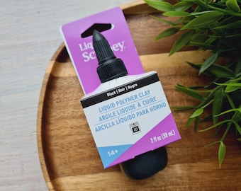 May include: A 2-ounce bottle of black liquid polymer clay. The bottle is labeled "Liquid Polymer Clay" in English, French, and Spanish. The label also includes the text "Black | Noir | Negro" and "14+".