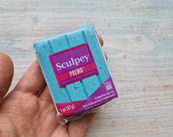 May include: A 2 ounce (57 gram) block of Sculpey Premo oven-bake clay in a light blue color. The packaging has a pink label with the brand name and product name.