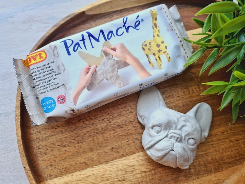 Pode incluir: Um pacote de argila de papel mach&eacute; Pat Mach&eacute; branca com uma girafa e uma m&atilde;o segurando um animal de papel mach&eacute; na frente. O pacote tem o texto "Pat Mach&eacute;" e "pronto para usar".