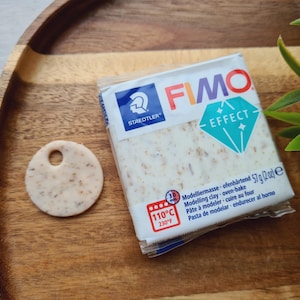 May include: A package of white FIMO Effect modeling clay with a blue diamond logo. The package is labeled with the text "STAEDTLER" and "FIMO EFFECT". The package also includes the text "Modelliermasse ofenhärtend" and "57g (2oz)".