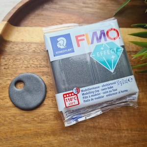 May include: A package of black FIMO Effect modeling clay. The package has a blue diamond design and the text "FIMO Effect" on it. The package also includes the text "Modelliermasse ofenhärtend 57 g (2 oz) e" and "110°C 230°F".