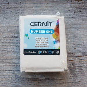 May include: A white package of CERNIT Number One opaque polymer clay. The package is labeled with the brand name, product name, and instructions for use. The package is 250g or 8.8 oz.
