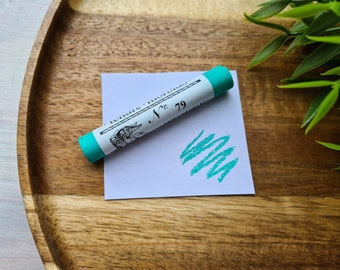 May include: A turquoise pastel stick with the text "tenere-morbido N° 79" on a white label. A turquoise pastel swatch is on a white card.
