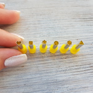 Può includere: Un set di otto tagliapasta con manici gialli, con diverse forme, tra cui un cuore, un quadrato, una stella, un cerchio e un triangolo.