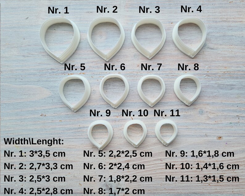 Może przedstawiać: Jedenastu białych plastikowych wycinarek do płatk&oacute;w kwiat&oacute;w w r&oacute;żnych rozmiarach, oznaczonych numerami od 1 do 11. Każda wycinarka jest pokazana z podanymi wymiarami szerokości i długości w centymetrach.