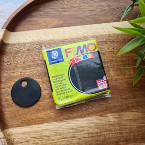 May include: A pack of black FIMO Kids modelling clay. The pack is yellow and black with the text "FIMO Kids" and "110&deg;C (230&deg;F)".
