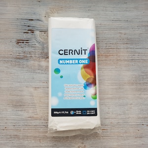 May include: A white package of CERNIT Number One polymer clay. The package is labeled with the brand name, product name, and instructions for use. The package is 17.7 ounces and contains 500 grams of clay.