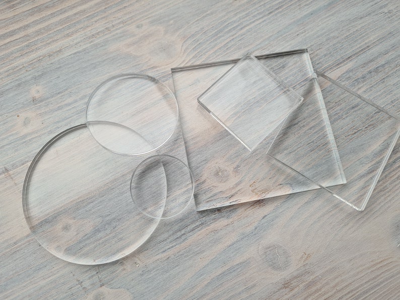 May include: A set of clear acrylic circles and squares of various sizes. The acrylic pieces are arranged on a light brown wooden surface.