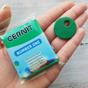 May include: A small package of green polymer clay labeled "CERNIT NUMBER ONE" with a green polymer clay circle with a hole in the center.