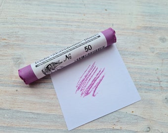 May include: A purple pastel stick with the text "Tendre - Morbidissimo - Bianco" and "No 50" on the label. A purple streak of color is visible on a white paper.