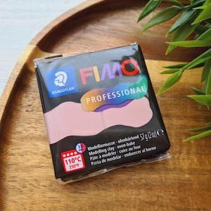 Può includere: Un pacchetto di pasta modellabile FIMO Professional di colore rosa chiaro. La confezione riporta il nome del marchio FIMO e STAEDTLER. La confezione include anche il testo "Professional" e "57g (2 oz)". La confezione include anche il testo "Modelliermasse ofenhärtend, Modelling clay - oven-bake, Pâte à modeler - cuire au four, Pasta de modelar - endurecer al horno".