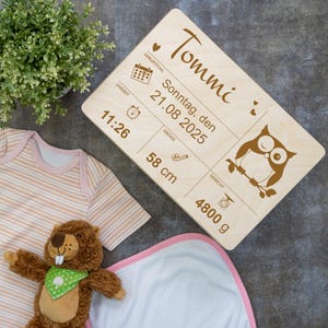 Peut inclure: Une plaque d'annonce de naissance en bois avec le nom "Tommi" et les détails de la naissance du bébé : dimanche 21 août 2025, 11h26, 58 cm et 4800 g. La plaque présente une illustration de hibou.
