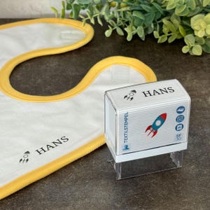 Timbro per tessuti per bambini con motivo a razzo e personalizzazione (47 x 18 mm)