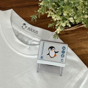 Timbro per tessuti per bambini con motivo pinguino e personalizzazione (47 x 18 mm)