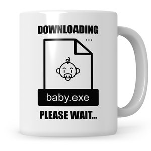 Könnte beinhalten: Weiße Keramiktasse mit einer schwarzen Grafik einer Datei mit der Bezeichnung "baby.exe" mit einem Baby-Symbol darin. Der Text "DOWNLOADING... PLEASE WAIT..." ist auf die Tasse gedruckt.