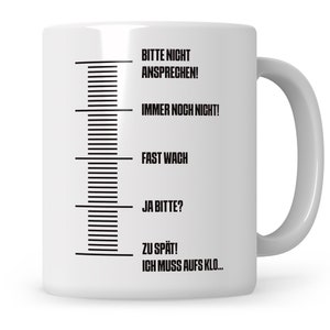 May include: White ceramic mug with black text that reads "Bitte nicht ansprechen! Immer noch nicht! Fast wach Ja bitte? Zu sp&auml;t! Ich muss aufs Klo..." The text is arranged vertically on the mug, with a black line separating each phrase.