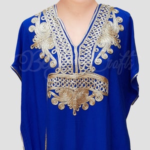 May include: A royal blue kaftan with gold embroidery. The embroidery features a floral design with intricate details.