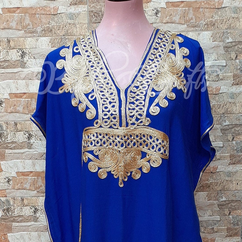 May include: A royal blue kaftan with gold embroidery. The embroidery features intricate patterns and designs.