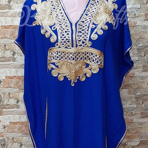May include: A royal blue kaftan with gold embroidery. The embroidery features intricate patterns and designs around the neckline and shoulders.