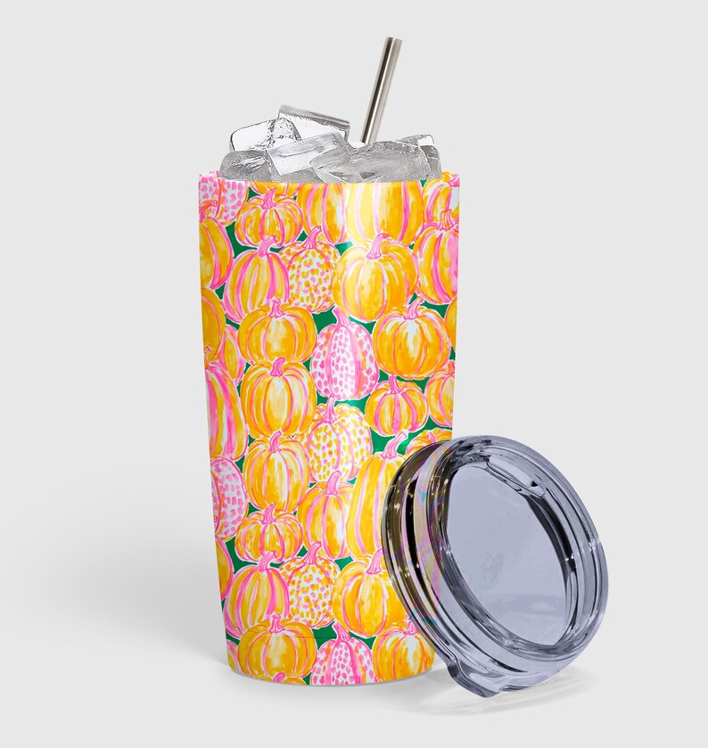 Pu&ograve; includere: Un bicchiere cilindrico in acciaio inossidabile con un vivace motivo di zucche gialle e arancioni con accenti rosa su sfondo verde scuro. Il bicchiere &egrave; riempito di cubetti di ghiaccio e include una cannuccia in metallo argentato e un coperchio.
