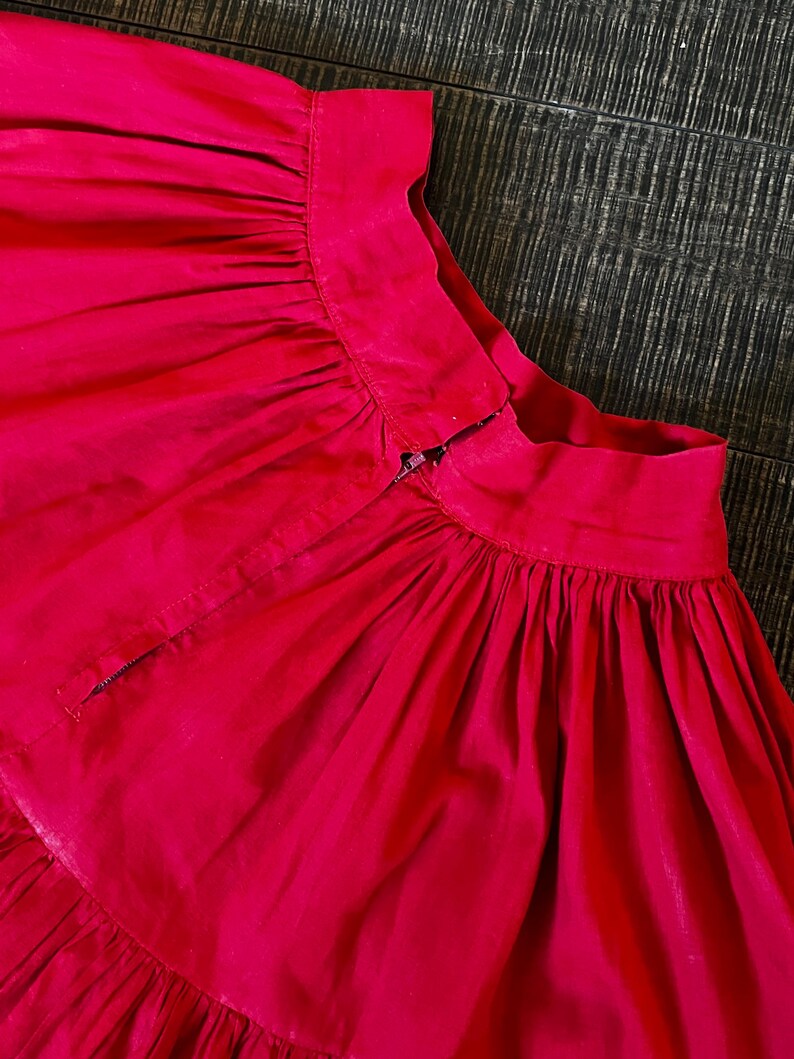 May include: A bright pink skirt with a gathered waist and a zipper closure in the back.