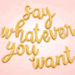 Könnte beinhalten: Goldene Folienballon-Girlande mit der Aufschrift "Say whatever you want".