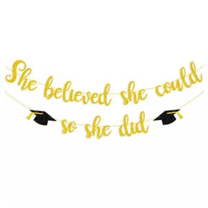 May include: Gold glitter graduation banner with black graduation caps and the text "She believed she could so she did."