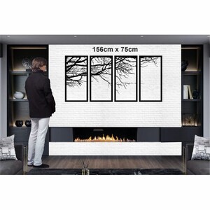 May include: Black metal wall art featuring four panels with a silhouette of tree branches. The art is 156cm x 75cm and is displayed on a white brick wall above a fireplace.
