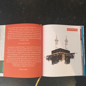 May include: An open book with text and an illustration of the Kaaba in Mecca. The text is in English and discusses the Hajj pilgrimage. The illustration depicts the Kaaba with two minarets.