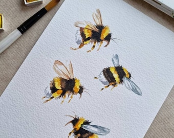 以下が含まれることがあります： 白い背景に、さまざまなポーズをとったミツバチが4匹描かれた水彩画。ミツバチは、黄色、黒、茶色の色合いで描かれており、羽にはグレーが少し使われています。