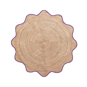 May include: A round, natural-toned jute rug with a scalloped edge. The rug's border is a deep purple, creating a contrast with the neutral tones of the woven jute. The rug has a circular pattern.