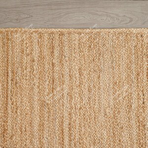 "Showcasing a timeless aesthetic, this hand-braided mat utilizes the natural golden hues of jute for a light, airy feel. The solid color and pronounced vertical texture make it effortlessly adaptable to various styles, including Coastal, Scandinavian, or Modern Farmhouse."