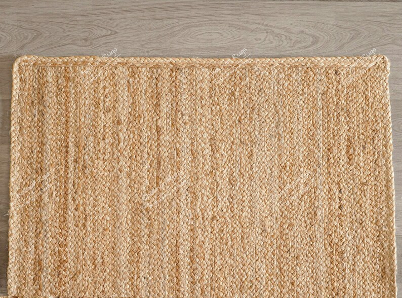 "Showcasing a timeless aesthetic, this hand-braided mat utilizes the natural golden hues of jute for a light, airy feel. The solid color and pronounced vertical texture make it effortlessly adaptable to various styles, including Coastal, Scandinavian, or Modern Farmhouse."
