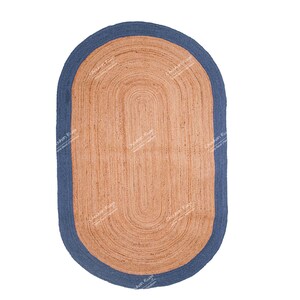 K&ouml;nnte beinhalten: Ein ovaler Teppich aus Naturfasern mit einem blauen Rand. Der Teppich ist aus Jute und hat eine gewebte Struktur.