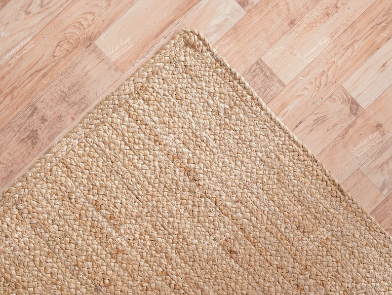 Rolled edge detail of the natural jute rug, showcasing sturdy craftsmanship, smooth finishing, and long-lasting everyday quality.