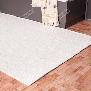 "Showcasing exceptional texture, this natural fiber rug is hand-woven using thick jute braids, resulting in a plush, tactile surface. The pale cream color reflects light beautifully, offering a bright, airy feel, making it an ideal choice for bedrooms or cozy reading nooks where comfort is key."